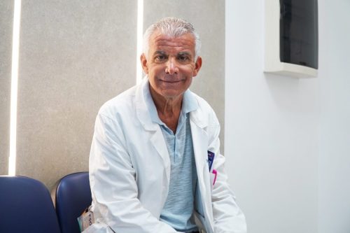 Medico anziano in camice bianco in clinica.